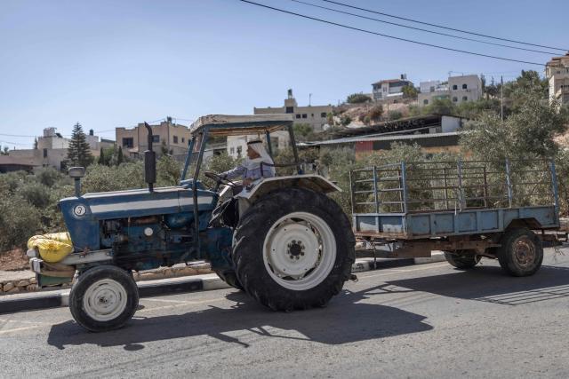 A farmer rides a tractor along the road in al-Mughayyir village near Ramallah in the Israeli-occupied West Bank, on October 4, 2026. (Photo by Ilia YEFIMOVICH / AFP)