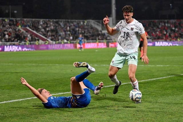 Kosovo's forward #14 Baton Zabergja falls in front of Austria's midfielder #18 Romano Schmid during the UEFA Nations League football match between Kosovo and Austria in Pristina on October 4, 2026. (Photo by Armend NIMANI / AFP)