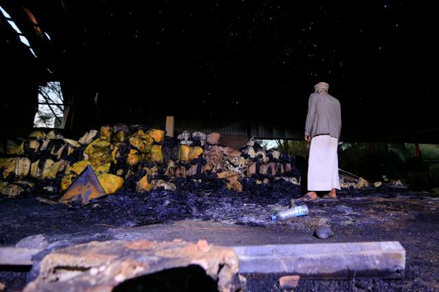 A Yemeni man inspects melted foam inside a factory after a strike that Houthi authorities-run media attributed to Saudi Arabia, in the Shamlan neighbourhood of Yemen's capital Sanaa on October 4, 2026. Yemen relapsed into war in July after years of calm, drawn into the regional conflict triggered by the US-Israeli offensive against Iran that began at the end of February. (Photo by Mohammed HUWAIS / AFP) / 