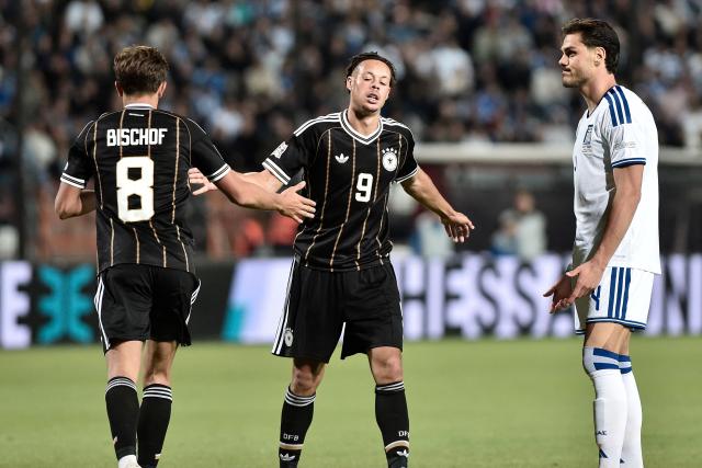 Germany's midfielder #8 Tom Bischof and Germany's midfielder #9 Kevin Schade celebrate as Greece's defender #4 Ntinos Mavropanos watches during the UEFA Nations League Group A2 football match between Greece and Germany at the Toumba Stadium in Thessaloniki on October 4, 2026. (Photo by Sakis Mitrolidis / AFP)