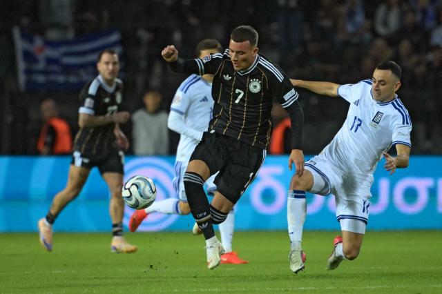 Germany's midfielder #07 Said El Mala (L) fights for the ball with Greece's defender #17 Manolis Saliakas (R) during the UEFA Nations League League A Group 2 matchday 4 match between Greece and Germany at Toumba Stadium in Thessaloniki on October 4, 2026. (Photo by Aris MESSINIS / AFP)