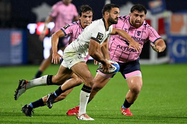 Toulon's French full-back Melvyn Jaminet passes the ball in front of Montpellier's French scrum-half Alexis Bernadet (L) and Montpellier's Georgian prop Luka Japaridze (R) during the French Top 14 rugby union match between Montpellier Herault Rugby (MHR) and Rugby Club Toulonnais (RCT) at the Stade de la Mosson in Montpellier, southern France, on October 4, 2026. (Photo by Gabriel BOUYS / AFP)