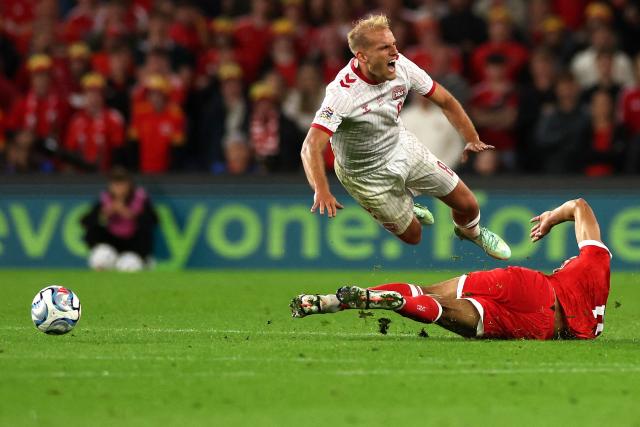 Denmark's midfielder #08 Gustav Isaksen (L) is fouled by Wales' defender #06 Ben Cabango (R) during the UEFA Nations League, league A, group 4 football match between Wales and Denmark, at the Cardiff City Stadium in Cardiff, south Wales, on October 4, 2026. (Photo by Adrian DENNIS / AFP)