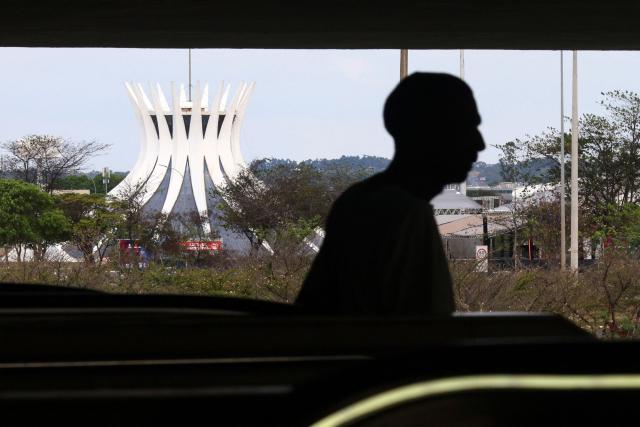 A man walks past the Metropolitan Cathedral of Our Lady of Aparecida during the presidential election in Brasilia on October 4, 2026. (Photo by Igo Estrela / AFP)