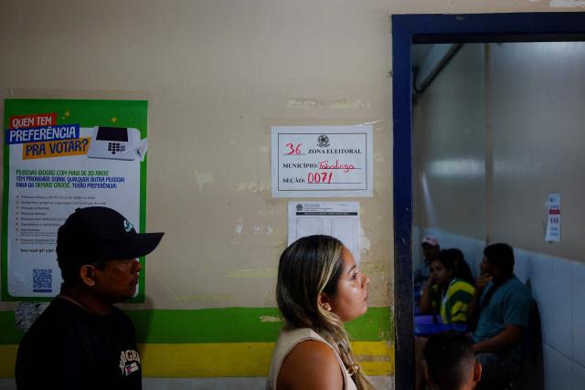 People queue to cast their votes during the presidential election at a polling station in Tabatinga, Amazonas state, Brazil, on October 4, 2026. Brazilians head to the polls in a highly polarized presidential election between incumbent leftist President Luiz Inacio Lula da Silva -seeking a fourth presidential mandate- and right-wing senator Flavio Bolsonaro, who emerged as the leading figure of the conservative movement following the conviction and imprisonment of his father, former president Jair Bolsonaro. (Photo by Pablo VERA / AFP)