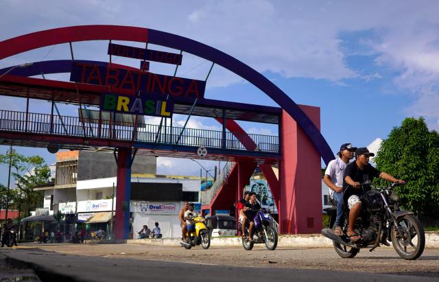 Motorcyclists cross the Brazil-Colombia border during the presidential election in Tabatinga, Amazonas state, Brazil, on October 4, 2026. Brazilians head to the polls in a highly polarized presidential election between incumbent leftist President Luiz Inacio Lula da Silva -seeking a fourth presidential mandate- and right-wing senator Flavio Bolsonaro, who emerged as the leading figure of the conservative movement following the conviction and imprisonment of his father, former president Jair Bolsonaro. (Photo by Pablo VERA / AFP)