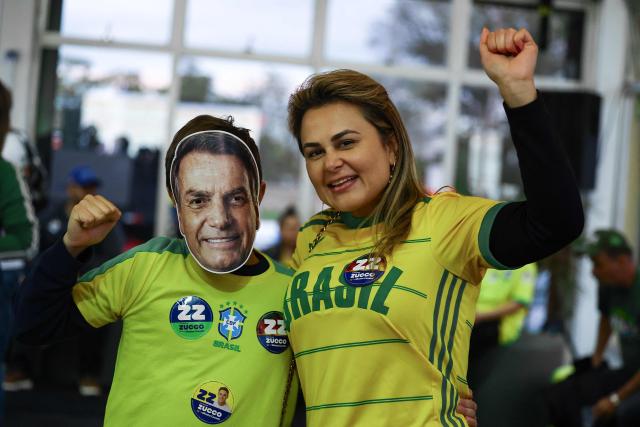 Supporters of Brazil's right-wing presidential candidate Flavio Bolsonaro react as they wait for the first results in in Porto Alegre, Brazil, on October 4, 2026. Brazilians waited anxiously on October 4, 2026, for the results of a tight election race between President Luiz Inacio Lula da Silva and Flavio Bolsonaro that will determine if the Latin American powerhouse joins a regional swing to the right championed by US President Donald Trump. (Photo by SILVIO AVILA / AFP)