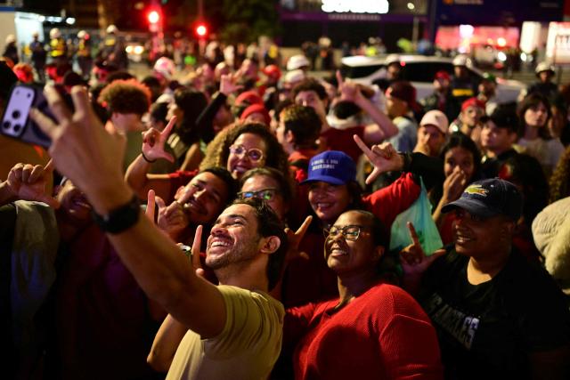 Supporters of Brazil's President and Presidential candidate Luiz Inacio Lula da Silva take a selfie after learining the partial results of the presidential election in Sao Paulo, Brazil, on October 4, 2026. Brazilian senator Flavio Bolsonaro, son of the far-right former president Jair Bolsonaro, is leading incumbent Luiz Inacio Lula da Silva in partial results from October 4, 2026, election. (Photo by Pablo PORCIUNCULA / AFP)