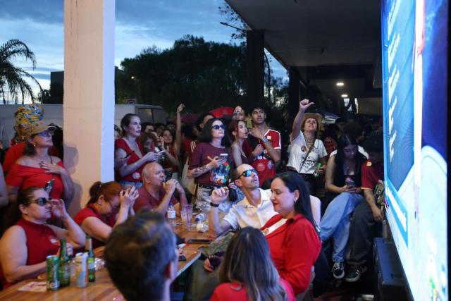 Supporters of Brazil's President and Presidential candidate Luiz Inacio Lula da Silva react following the partial results of the presidential election in Brasilia on October 4, 2026. Brazilian senator Flavio Bolsonaro, son of the far-right former president Jair Bolsonaro, is leading incumbent Luiz Inacio Lula da Silva in partial results from October 4, 2026, election. (Photo by Igo Estrela / AFP)