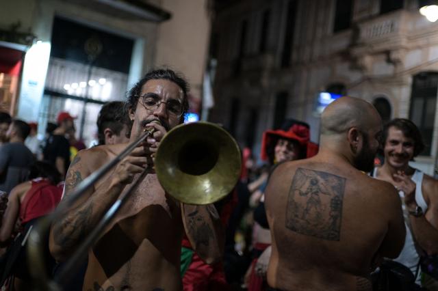 A supporter of Brazil's President and presidential candidate Luiz Inacio Lula da Silva plays the trombone following the first results of the presidential election in Rio de Janeiro, Brazil, on October 4, 2026. Brazilian senator Flavio Bolsonaro, son of the far-right former president Jair Bolsonaro, is leading incumbent Luiz Inacio Lula da Silva in partial results from October 4, 2026, election. (Photo by TERCIO TEIXEIRA / AFP)