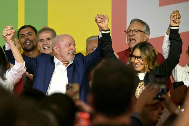 Brazil's President and re-election candidate for the Workers' Party (PT) Luiz Inacio Lula da Silva and First Lady Rosangela Janja da Silva raise their arms following the partial results of the presidential election in Sao Paulo, Brazil on October 4, 2026. Brazilian senator Flavio Bolsonaro, son of the far-right former leader Jair Bolsonaro, finished ahead of President Luiz Inacio Lula da Silva in the election on October 4, 2026, which will go to a run-off in three weeks. (Photo by NELSON ALMEIDA / AFP)