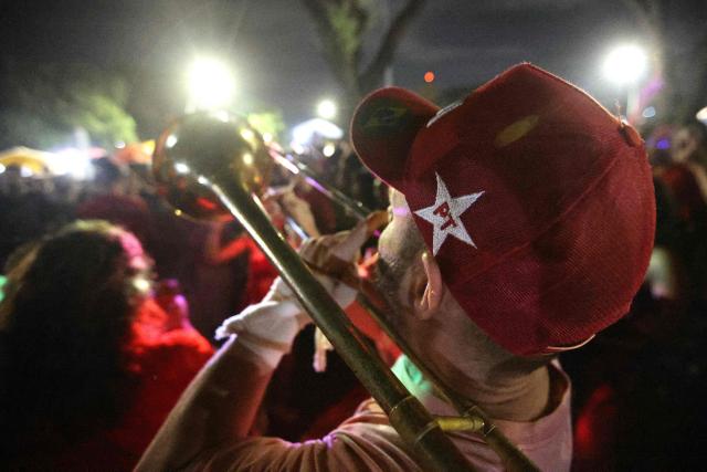 A supporter of Brazil's President and Presidential candidate Luiz Inacio Lula da Silva plays a trumpet following the results of the presidential election in Brasilia on October 4, 2026. Brazilian senator Flavio Bolsonaro, son of the far-right former leader Jair Bolsonaro, finished ahead of President Luiz Inacio Lula da Silva in the election on October 4, 2026, which will go to a run-off in three weeks. (Photo by Igo Estrela / AFP)