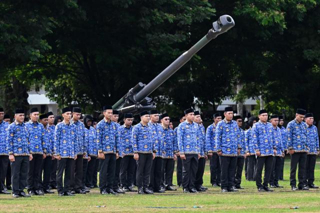 Indonesian civil government staff attend the 81st anniversary of the Indonesian National Armed Forces (TNI) in Banda Aceh on October 5, 2026. (Photo by CHAIDEER MAHYUDDIN / AFP)