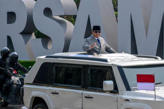Indonesian President Prabowo Subianto, waves from an open-top vehicle as he arrives for the 81st Indonesian National Armed Forces Day Parade at the TNI Headquarters in Cilangkap, East Jakarta, on Monday, October 5, 2026. (Photo by BAY ISMOYO / AFP)