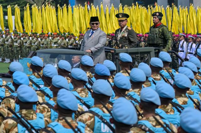 Indonesia's President Prabowo Subianto (L), accompanied by Indonesian Armed Forces Commander General Agus Subiyanto (C) and other senior officers, passes by a contingent of Indonesian peacekeepers during the 81st Indonesian National Armed Forces Day Parade in Cilangkap, East Jakarta, on October 5, 2026. (Photo by BAY ISMOYO / AFP)