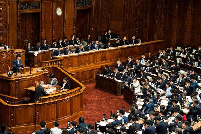 Japan's Prime Minister Sanae Takaichi (L) delivers a speech during a plenary session of the House of Representatives at the National Diet in Tokyo on October 5, 2026. (Photo by Yuichi YAMAZAKI / AFP)