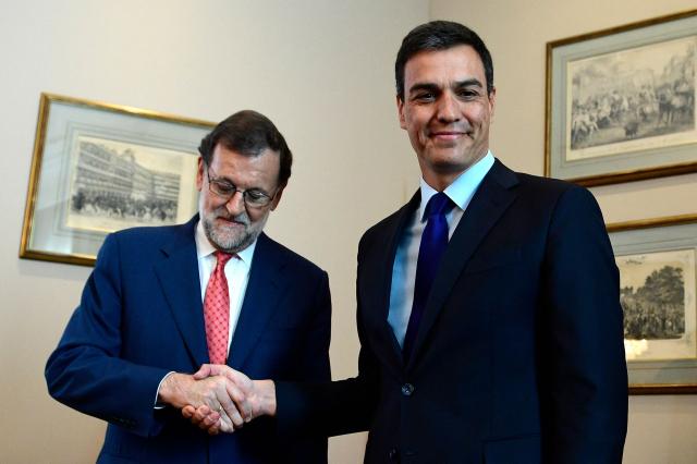 (FILES) Spain's interim Prime Minister Mariano Rajoy (L) shakes hands with leader of Spanish Socialist Party (PSOE) Pedro Sanchez at the Spanish parliament in Madrid on August 2, 2016 before a meeting on forming a government in a bid to unblock seven months of political paralysis after a second round of inconclusive elections. Spanish Prime Minister Pedro Sanchez called early election for November 29 after housing set-back during a televised speech on October 5, 2026. (Photo by GERARD JULIEN / AFP)