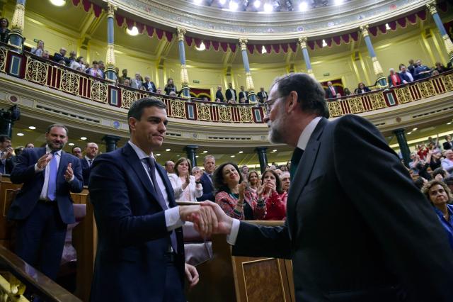 (FILES) Spain's new Prime Minister Pedro Sanchez (L) shakes hands with Spain's out-going Prime Minister Mariano Rajoy (R) after a vote on a no-confidence motion at the Lower House of the Spanish Parliament in Madrid on June 01, 2018. Spanish Prime Minister Pedro Sanchez called early election for November 29 after housing set-back during a televised speech on October 5, 2026. (Photo by PIERRE-PHILIPPE MARCOU / AFP)