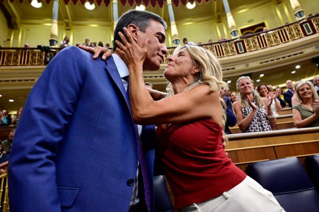 (FILES) Acting Prime Minister Pedro Sanchez is kissed by acting Deputy Prime Minister and Minister of Labor and Social Economy Yolanda Diaz upon their arrival to attend the Parliament's constitutive sitting at the Congress of Deputies in Madrid on August 17, 2023. Spanish Prime Minister Pedro Sanchez called early election for November 29 after housing set-back during a televised speech on October 5, 2026. (Photo by JAVIER SORIANO / AFP)