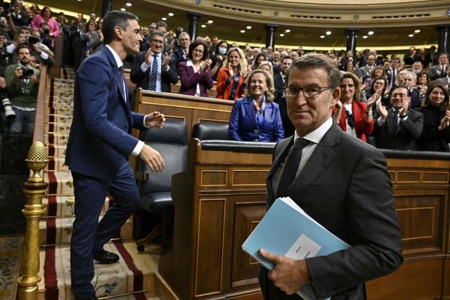 (FILES) Spain's acting Prime Minister Pedro Sanchez (L) is congratulated by Partido Popular (PP) leader Alberto Nunez Feijoo after winning a parliamentary vote to elect Spain's next premier, at the Congress of Deputies in Madrid on November 16, 2023. Spanish Prime Minister Pedro Sanchez called early election for November 29 after housing set-back during a televised speech on October 5, 2026. (Photo by JAVIER SORIANO / AFP)