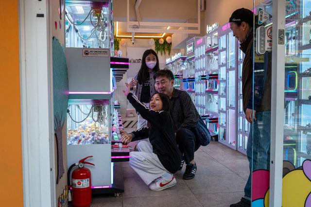People visit a claw crane game shop near the Mangwon Market in Seoul on October 5, 2026. (Photo by Philip FONG / AFP)