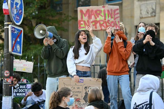Protesting students gather and hold a placard reading "Marine in jail" as they carry out a blockading action at the Claude Monet secondary school, in Paris, on October 5, 2026. The start of a "black week"? Hundreds of high schools are going to close again, at least partially, on October 5, 2026, on the eve of a new day of mobilisation, which unions are calling on people to join, and as calls for a hard blockade are flourishing on social media as students demand more resources for their schools and denouncce the unsanitary state of buildings, overcrowded classes, or unreplaced absences, particularly in working-class neighbourhoods, or even the inequalities created by Parcoursup. (Photo by LOU BENOIST / AFP)