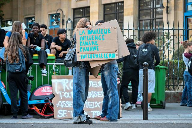 Protesting students hold a placard reading "The suburbs influence Paname (Paris), Paname infulences the world" as they carry out a blockading action at the Claude Monet secondary school, in Paris, on October 5, 2026. The start of a "black week"? Hundreds of high schools are going to close again, at least partially, on October 5, 2026, on the eve of a new day of mobilisation, which unions are calling on people to join, and as calls for a hard blockade are flourishing on social media as students demand more resources for their schools and denouncce the unsanitary state of buildings, overcrowded classes, or unreplaced absences, particularly in working-class neighbourhoods, or even the inequalities created by Parcoursup. (Photo by LOU BENOIST / AFP)