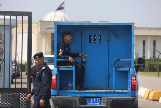 An Iraqi police patrol transports Iraqi detainees to the Karkh Court during the trial of six French citizens accused of terrorism in Baghdad, on October 5, 2026. Six French nationals are due to stand trial in Iraq as the country assumes responsibility for prosecuting thousands of suspected Islamic State group members. Their identities remain unclear, but they are part of a group of 47 French citizens transferred from Syria last year. The jihadist group swept across Syria and Iraq in 2014, committing massacres and forcing women and girls into sexual slavery. (Photo by AHMAD AL-RUBAYE / AFP)