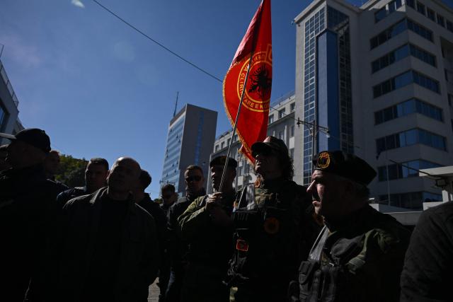 People in military uniform take part in a protest in front of the parliament building during an extraordinary session in Pristina on October 5, 2026. The Kosovo Assembly adopted a bill on October 5, 2026 limiting significantly the jurisdiction of a Hague Tribunal to try war crimes and crimes against humanity committed during the war in the 1990s, following the court's recent high-profile convictions of former guerrilla leaders. (Photo by Armend NIMANI / AFP)