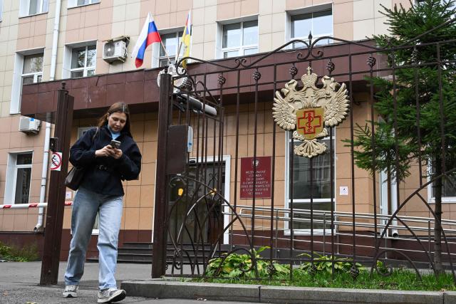 A woman leaves the grounds of the headquarters of Russia's consumer and health watchdog Rospotrebnadzor in Moscow on October 5, 2026. Russian officials on October 5, 2026 downplayed reports that a laboratory technician in Siberia had died of plague, insisting the situation was under control and that post-mortem tests had not found traces of the disease. (Photo by Igor IVANKO / AFP)