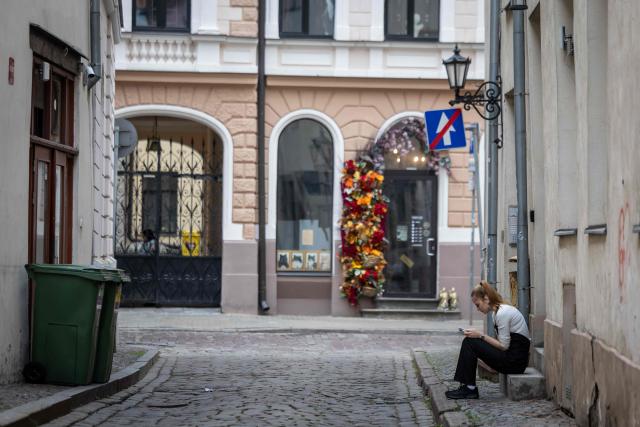 This photograph taken on October 4, 2026 shows a woman using her mobile phone on the street in Riga, Latvia. (Photo by Wojtek RADWANSKI / AFP)