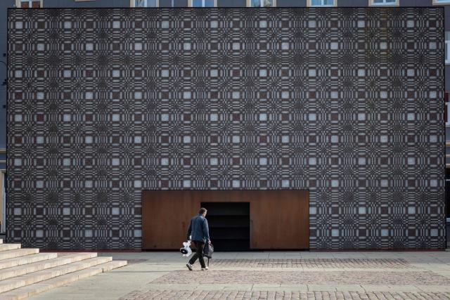 This photograph taken on October 4, 2026 shows a man walking in front of the "History Tactile" - Memorial to the Victims of the Soviet Occupation in Riga, Latvia. (Photo by Wojtek RADWANSKI / AFP)