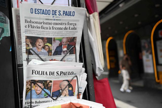 Copies of the newspapers O Estado de Sao Paulo and Folha de Sao Paulo displaying coverage of Brazil's presidential election results are seen at a newsstand in Sao Paulo, Brazil, on October 5, 2026. The Sao Paulo stock exchange opened sharply higher on October 5 after a surprise first round election result saw right-wing senator Flavio Bolsonaro edge past incumbent Luiz Inacio Lula da Silva. (Photo by Luis ROBAYO / AFP)