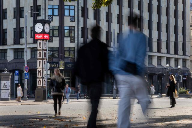 This photograph taken on October 4, 2026, shows passers-by walking next to the Freedom Monument (Brivibas Piemineklis) in downtown Riga, Latvia. (Photo by Wojtek RADWANSKI / AFP)