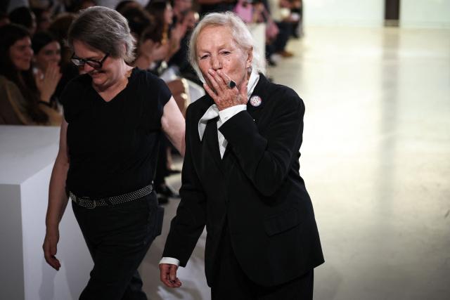 French designer Agnes Trouble known as Agnes b. (R) aknowledges the audience at the end of the Agnes b. Women's Spring/Summer 2027 collection fashion show as part of the Paris Fashion Week, in Paris on October 5, 2026. (Photo by SIMON WOHLFAHRT / AFP)