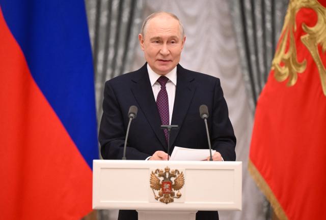 In this pool photograph distributed by the Russian state agency Sputnik, Russia's President Vladimir Putin hosts a ceremony to present state awards to mentors and teachers of participants in Russia's military action in Ukraine, at the Kremlin in Moscow on October 5, 2026. (Photo by Kristina Solovyova / POOL / AFP)