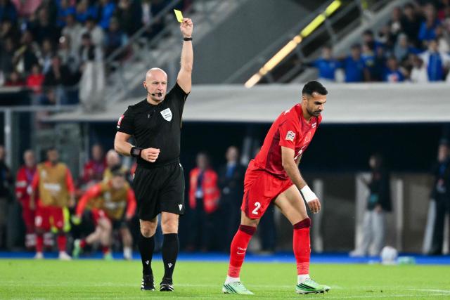 Polish referee Szymon Marciniak gives a yellow card to Turkey's defender Zeki Celik during the UEFA Nations League football match (League A day 4, Group A1) between Italy and Turkey at the Renato Dall'Ara Stadium in Bologna on October 5, 2026. (Photo by Alberto PIZZOLI / AFP)
