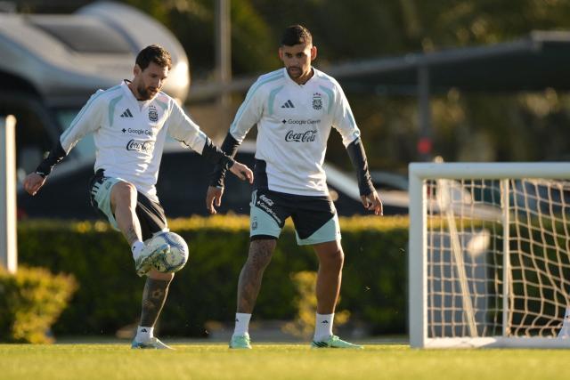 Argentina's forward Lionel Messi (L) passes the ball next to teammate defender Cristian Romero during a football training session at the Argentine Football Association (AFA) training camp in Ezeiza, Buenos Aires Province, on October 5, 2026, ahead of the friendly match against Benin. (Photo by JUAN MABROMATA / AFP)