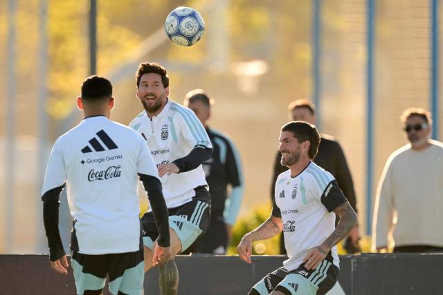 Argentina's forward Lionel Messi (C) looks at the ball next to teammate midfielder Rodrigo De Paul (R) during a football training session at the Argentine Football Association (AFA) training camp in Ezeiza, Buenos Aires Province, on October 5, 2026, ahead of the friendly match against Benin. (Photo by JUAN MABROMATA / AFP)