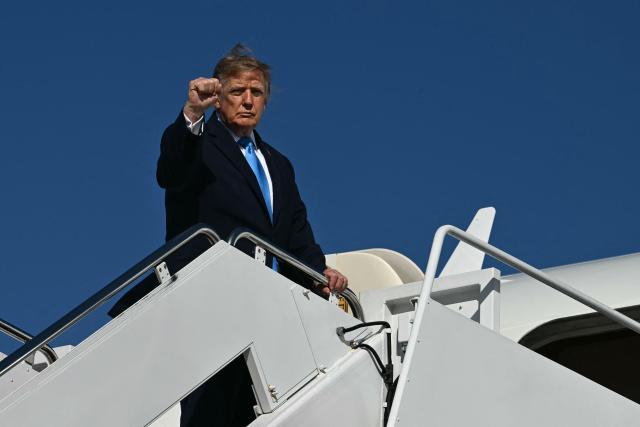 US President Donald Trump raises his fist as he boards Air Force One at Joint Base Andrews, Maryland, on October 5, 2026. Trump is travelling to Nebraska to speak at a campaign rally. (Photo by Kent NISHIMURA / AFP)