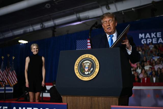 Executive assistant to US President Donald Trump, Natalie Harp, stands on stage with US President Donald Trump as he signs an executive order during a campaign rally at Pinnacle Bank Expo Center in Grand Island, Nebraska, on October 5, 2026. (Photo by Kent NISHIMURA / AFP)