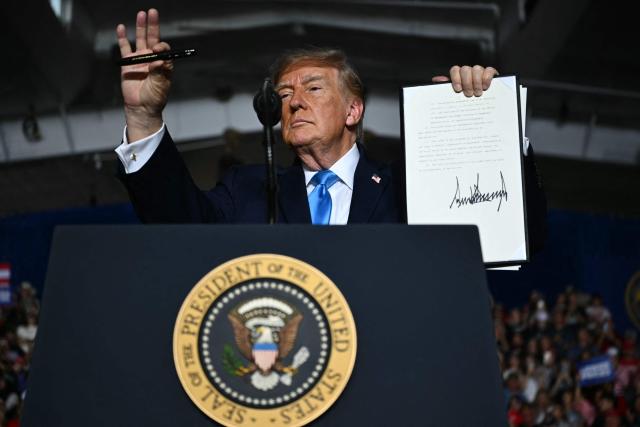 US President Donald Trump shows the crowd an executive order he just signed during a campaign rally at Pinnacle Bank Expo Center in Grand Island, Nebraska, on October 5, 2026. (Photo by Kent NISHIMURA / AFP)