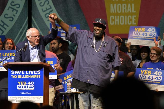 US Senator Bernie Sanders (I-VT) raises his arm with US rapper Killer Mike during a California Wealth Tax rally in Los Angeles, California on October 5, 2026. (Photo by Frederic J. Brown / AFP)