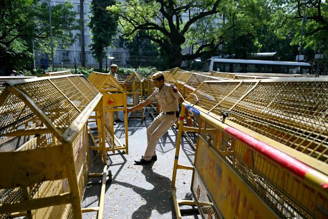 Police personnel place barricades in front of the Election Commission of India office in New Delhi on October 6, 2026, during a demonstration against the country's Chief Election Commissioner Gyanesh Kumar calling for his resignation over alleged irregularities in the Special Intensive Revision (SIR) of electoral rolls. India's Supreme Court ordered the government and the national election body on October 5, to explain decisions linked to a large-scale revision of voter rolls that prompted accusations of wrongdoing. Opposition parties and activists have organised protests and called for the resignation of Kumar, alleging that the revision had improperly removed millions of names from voter lists. (Photo by Arun SANKAR / AFP)