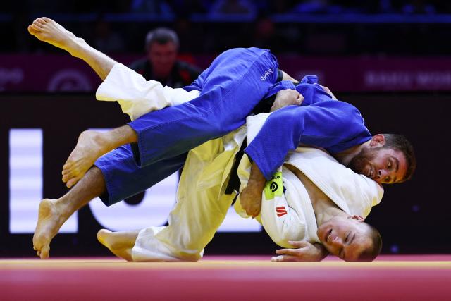 Russia's Danil Lavrentev (white) competes against United Arab Emirates' Kazbek Naguchev in the men's under 73 kg round of 32 at the World Judo Championships in Baku on October 6, 2026. (Photo by Anne-Christine POUJOULAT / AFP)