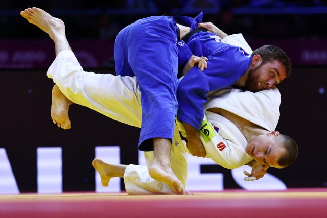 Russia's Danil Lavrentev (white) competes against United Arab Emirates' Kazbek Naguchev in the men's under 73 kg round of 32 at the World Judo Championships in Baku on October 6, 2026. (Photo by Anne-Christine POUJOULAT / AFP)