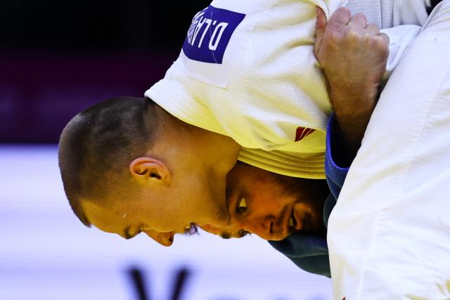 Russia's Danil Lavrentev (white) competes against United Arab Emirates' Kazbek Naguchev in the men's under 73 kg round of 32 at the World Judo Championships in Baku on October 6, 2026. (Photo by Anne-Christine POUJOULAT / AFP)