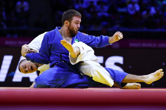 Russia's Danil Lavrentev (white) competes against United Arab Emirates' Kazbek Naguchev in the men's under 73 kg round of 32 at the World Judo Championships in Baku on October 6, 2026. (Photo by Anne-Christine POUJOULAT / AFP)