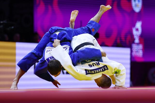 Russia's Danil Lavrentev (white) competes against United Arab Emirates' Kazbek Naguchev in the men's under 73 kg round of 32 at the World Judo Championships in Baku on October 6, 2026. (Photo by Anne-Christine POUJOULAT / AFP)