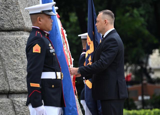 Poland's President Karol Nawrocki (C) takes part in a wreath-laying ceremony at the Rizal Monument in Manila on October 6, 2026. (Photo by Ted ALJIBE / AFP)